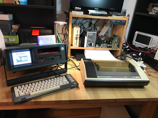 a commodore sx-64 and a needle printer on a table